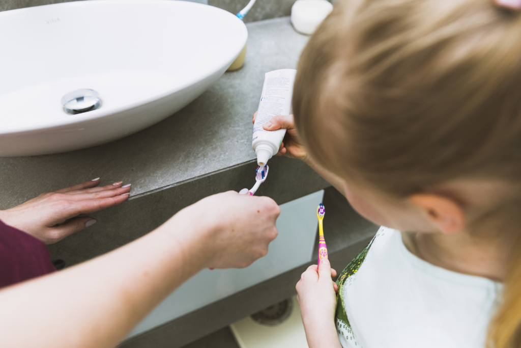 Petite fille qui applique du dentifrice