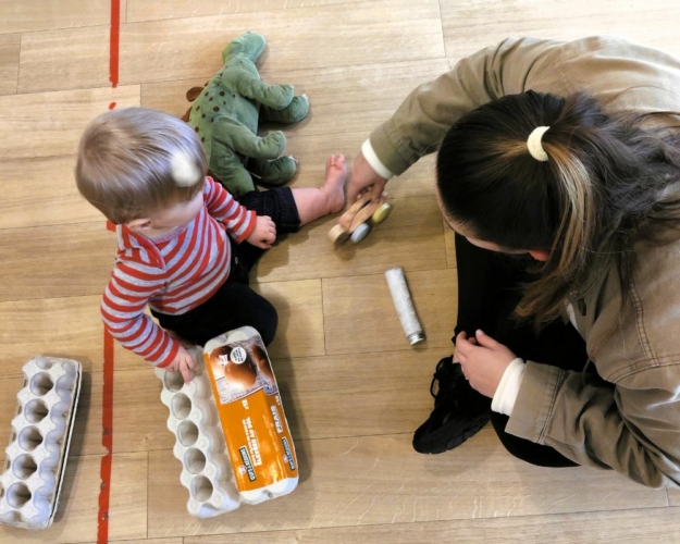 Enfants jouant avec une professionnelle en crèche